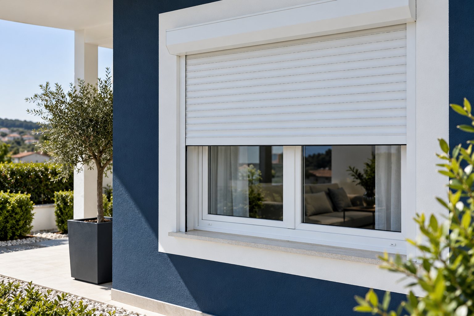 Estore exterior branco parcialmente fechado sobre uma janela em PVC
